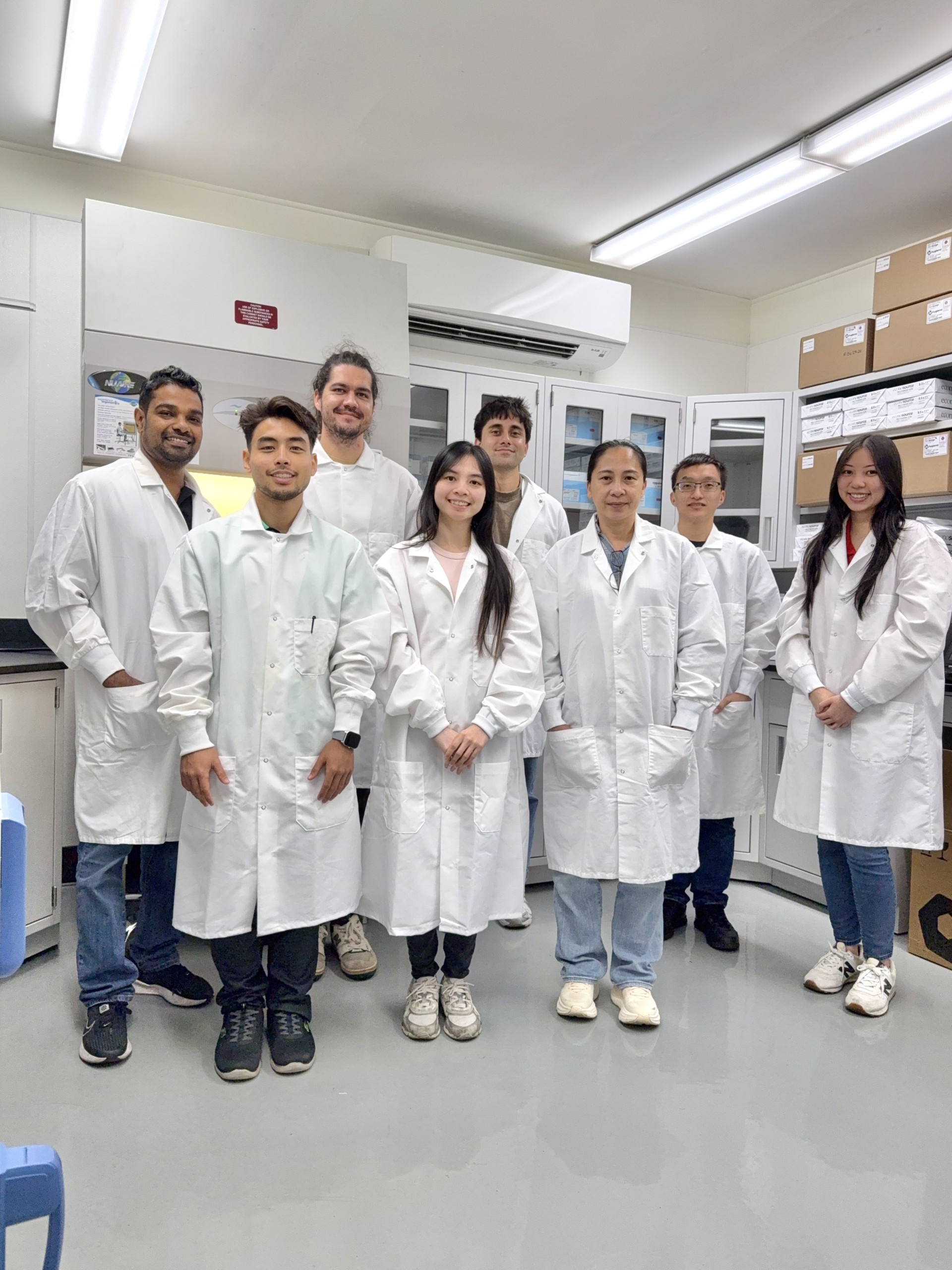 HPC Foods Laboratory team members working together in the lab, wearing lab coats and gloves while analyzing samples
